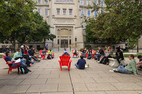 Students sitting on the ground. Links to Closely Held Business Stock