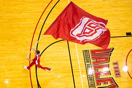 A student running with the Bradley flag. Links to Beneficiary Designations